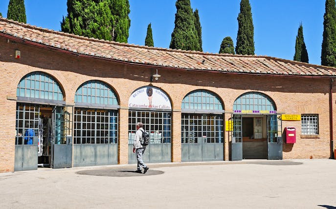 Tourist entering ticket office for Catacombs of St. Callixtus in Rome.