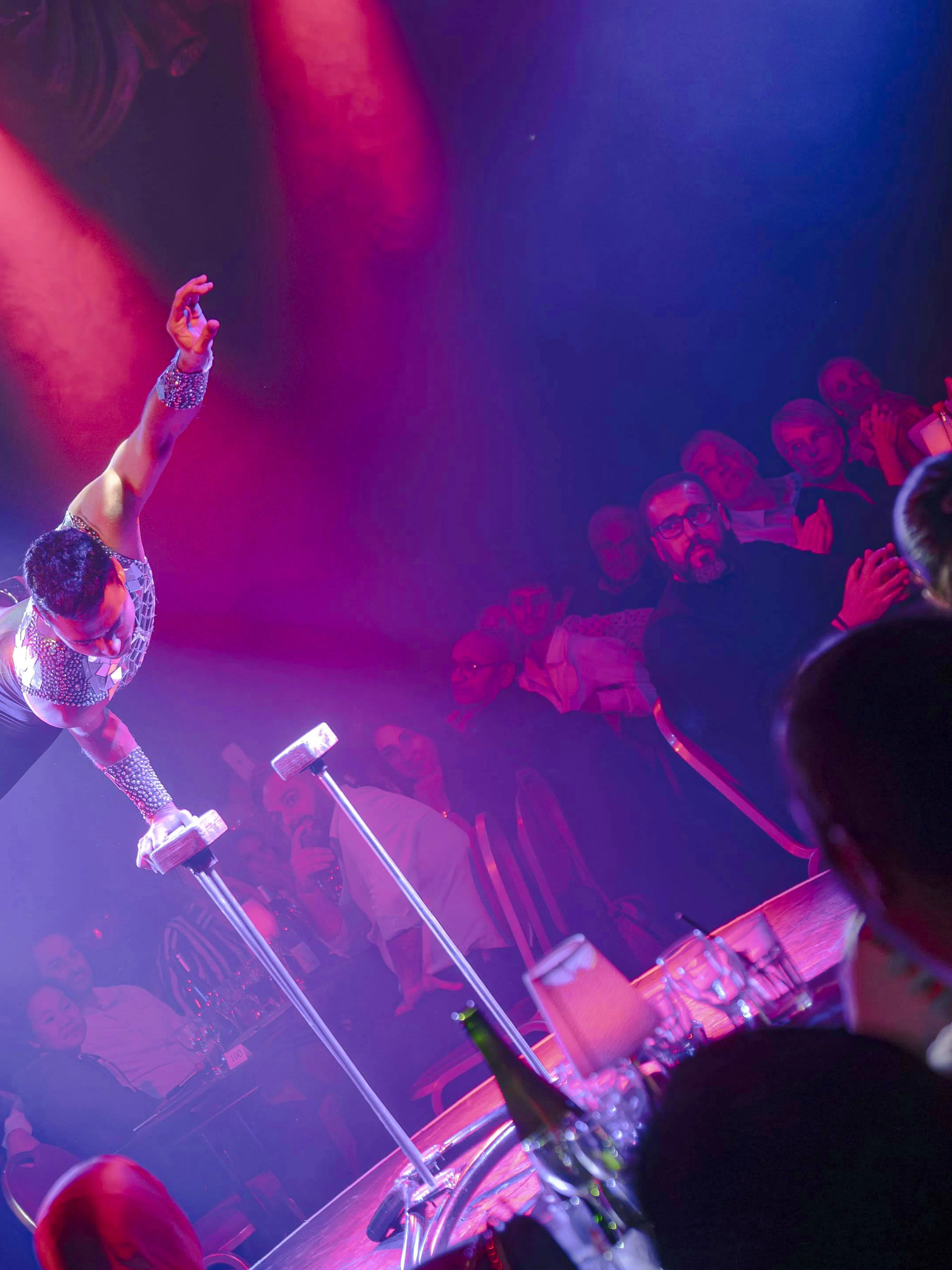 Performer balancing on handstand canes at Les Nuits de Lola Oh Cesar show in France.
