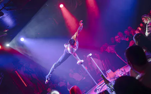 Performer balancing on handstand canes at Les Nuits de Lola Oh Cesar show in France.