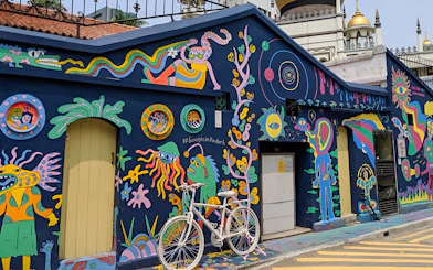 Colorful street art mural in Kampong Gelam, Singapore, featuring vibrant characters and patterns.