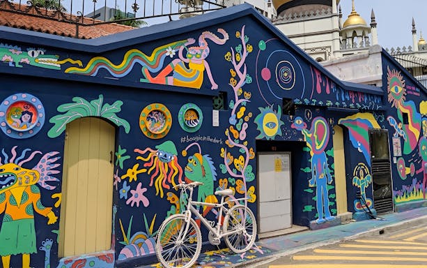 Colorful street art mural in Kampong Gelam, Singapore, featuring vibrant characters and patterns.