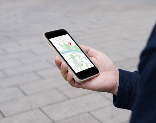 Traveler navigating city streets using a mobile map app in an urban setting.