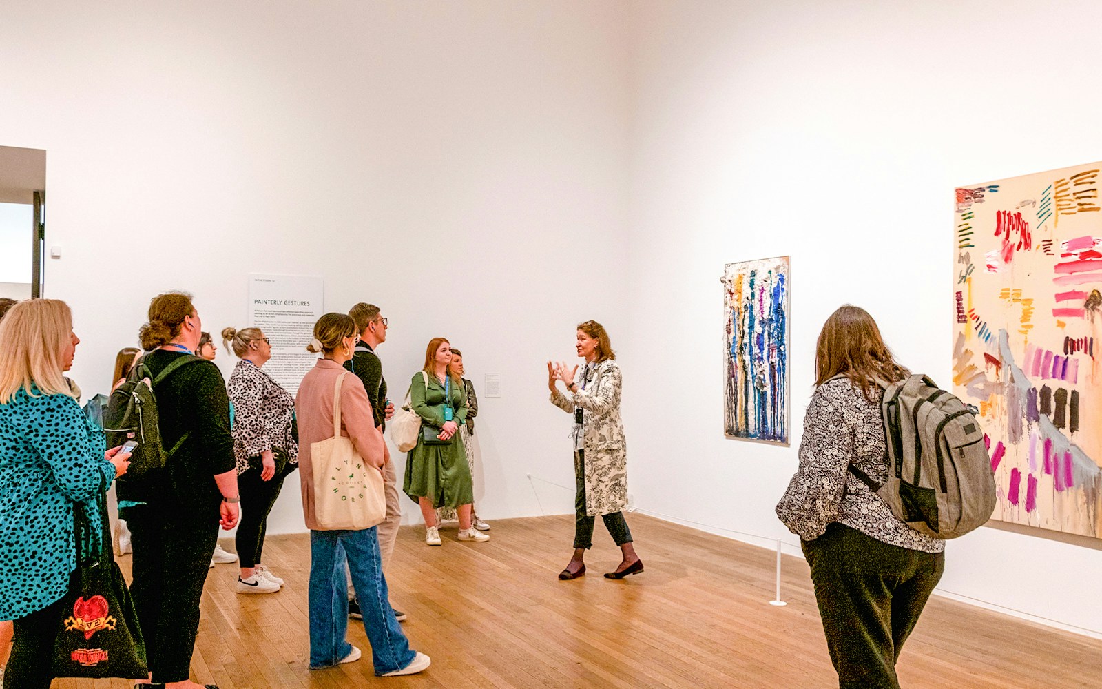 Visitors exploring art exhibits during a guided tour inside Tate Modern, London.