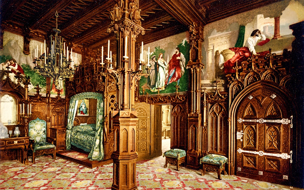 Neuschwanstein Castle interior with ornate wooden carvings and colorful murals.