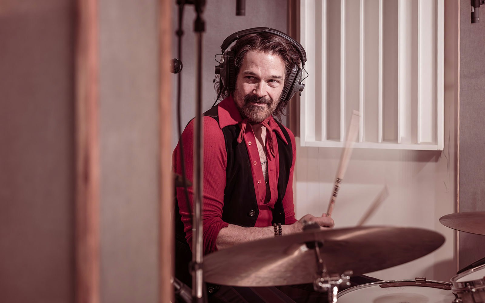 Drummer playing in a recording studio with headphones, related to Stereophonic tour.