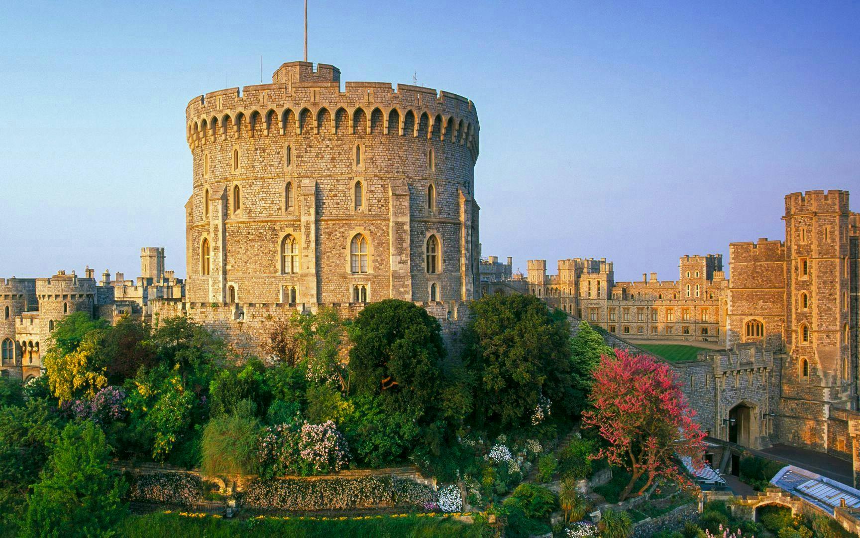 Windsor Castle exterior with round tower and lush gardens in England.