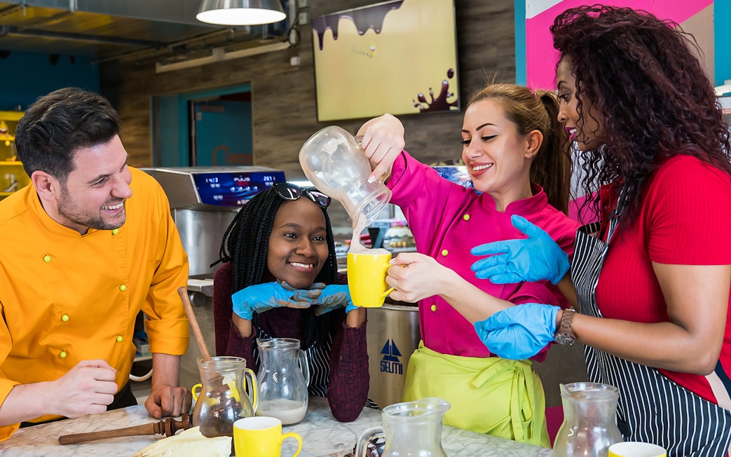 Participants enjoying a chocolate workshop in Vienna, pouring chocolate into mugs.