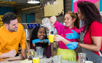 Participants enjoying a chocolate workshop in Vienna, pouring chocolate into mugs.