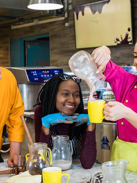 Participants enjoying a chocolate workshop in Vienna, pouring chocolate into mugs.