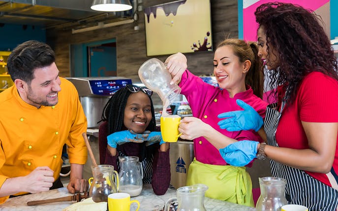 Participants enjoying a chocolate workshop in Vienna, pouring chocolate into mugs.