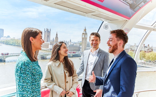 Group enjoying view of Big Ben and Houses of Parliament from London Eye capsule.