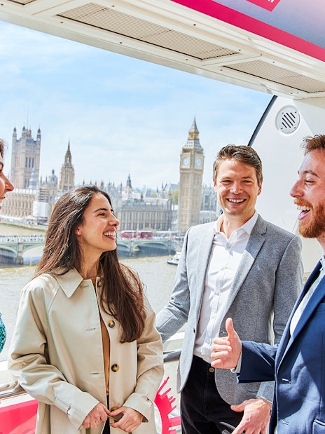 Group enjoying view of Big Ben and Houses of Parliament from London Eye capsule.