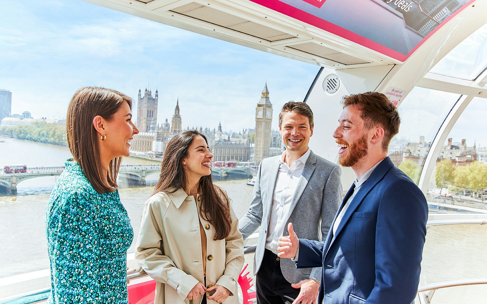 Group enjoying view of Big Ben and Houses of Parliament from London Eye capsule.