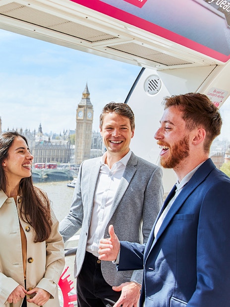 Group enjoying view of Big Ben and Houses of Parliament from London Eye capsule.