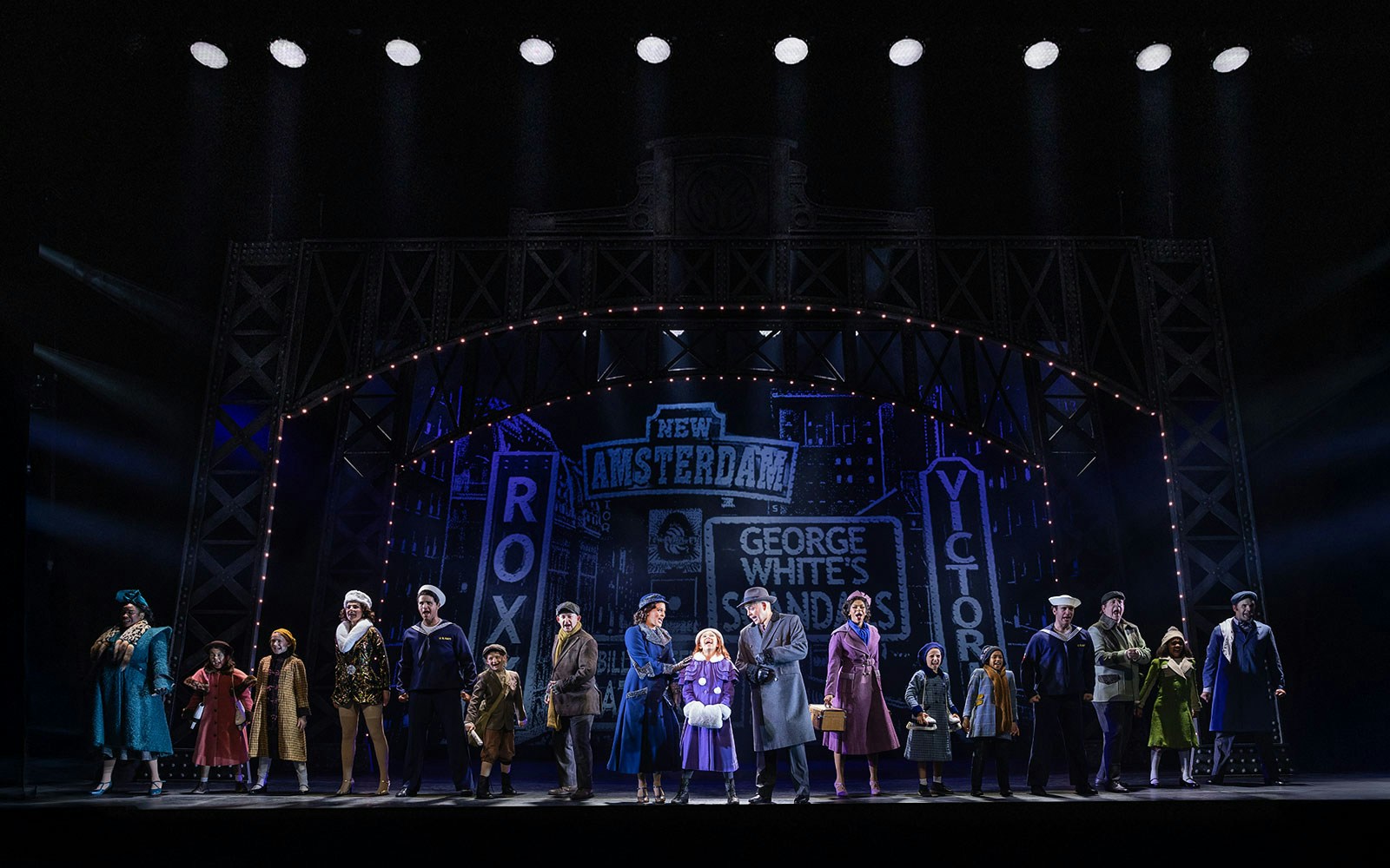 Stage performance of "Annie" with cast in period costumes under New Amsterdam Theatre lights.