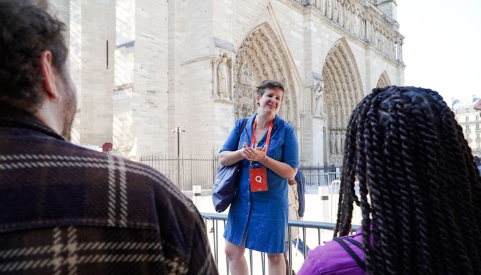 Guide speaking to tourists in front of Notre Dame Cathedral, Paris.