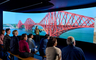 Visitors watching a video of the Forth Bridge in Scotland.