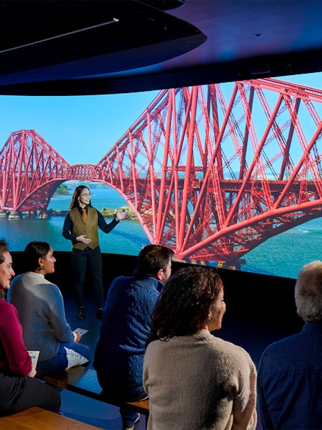 Visitors watching a video of the Forth Bridge in Scotland.