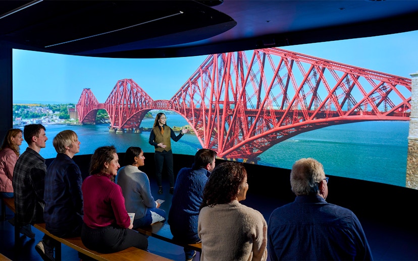Visitors watching a video of the Forth Bridge in Scotland.