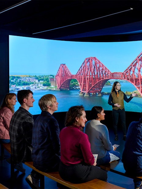 Visitors watching a video of the Forth Bridge in Scotland.