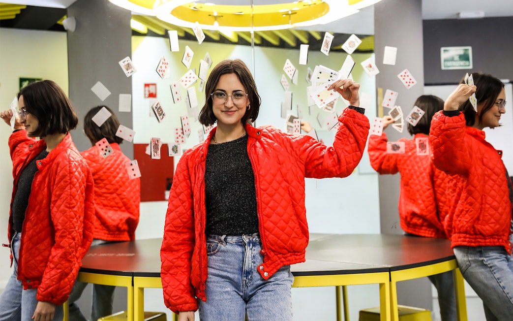 Person holding playing cards in front of mirrors at Museum of Illusions, Madrid.