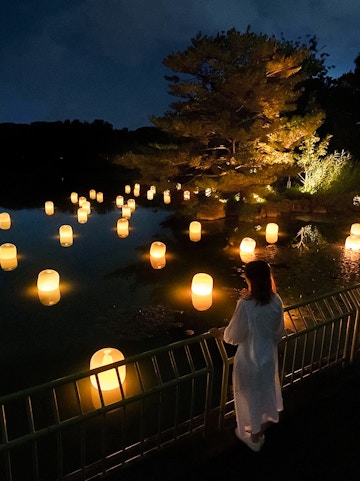 Lanterns floating on water at night in teamLab Botanical Garden, Osaka.