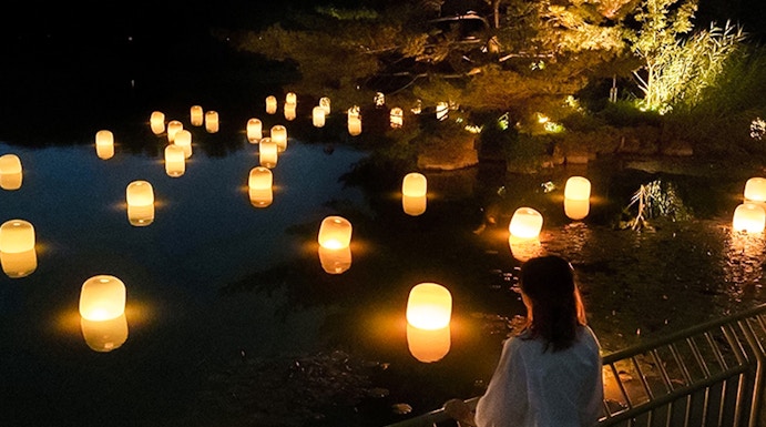 Lanterns floating on water at night in teamLab Botanical Garden, Osaka.
