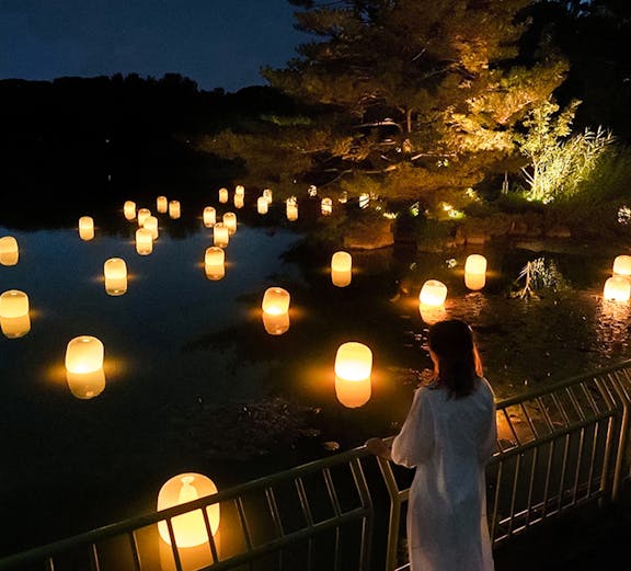 Lanterns floating on water at night in teamLab Botanical Garden, Osaka.