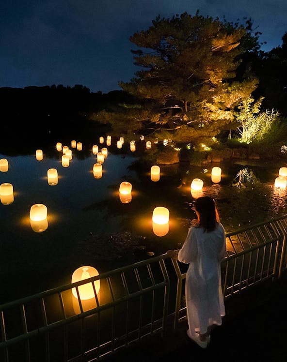 Lanterns floating on water at night in teamLab Botanical Garden, Osaka.