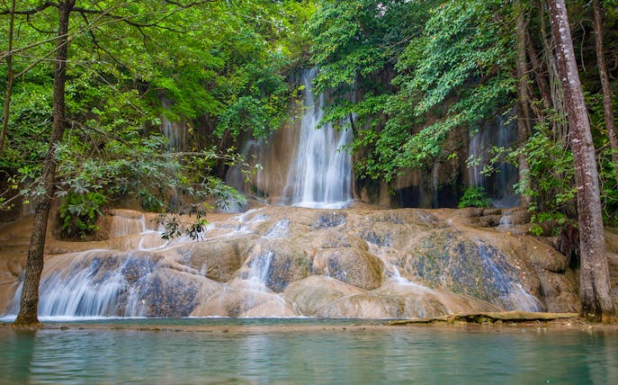 Sticky Waterfall cascading over limestone rocks surrounded by lush greenery in Chiang Mai.
