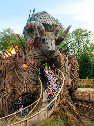 Roller coaster at Alton Towers with riders on wooden track, London attractions.