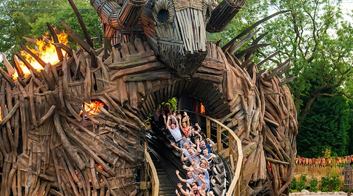 Roller coaster at Alton Towers with riders on wooden track, London attractions.