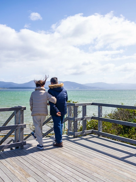 Couple enjoying Bruny Island coastline view, part of Hobart full-day guided tour.