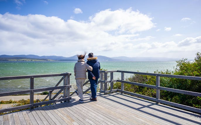 Couple enjoying Bruny Island coastline view, part of Hobart full-day guided tour.