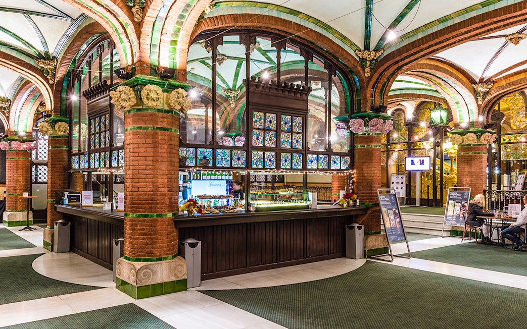 Palau de la Musica Catalana counter area with stained glass and brick arches.