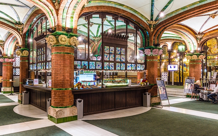 Palau de la Musica Catalana counter area with stained glass and brick arches.