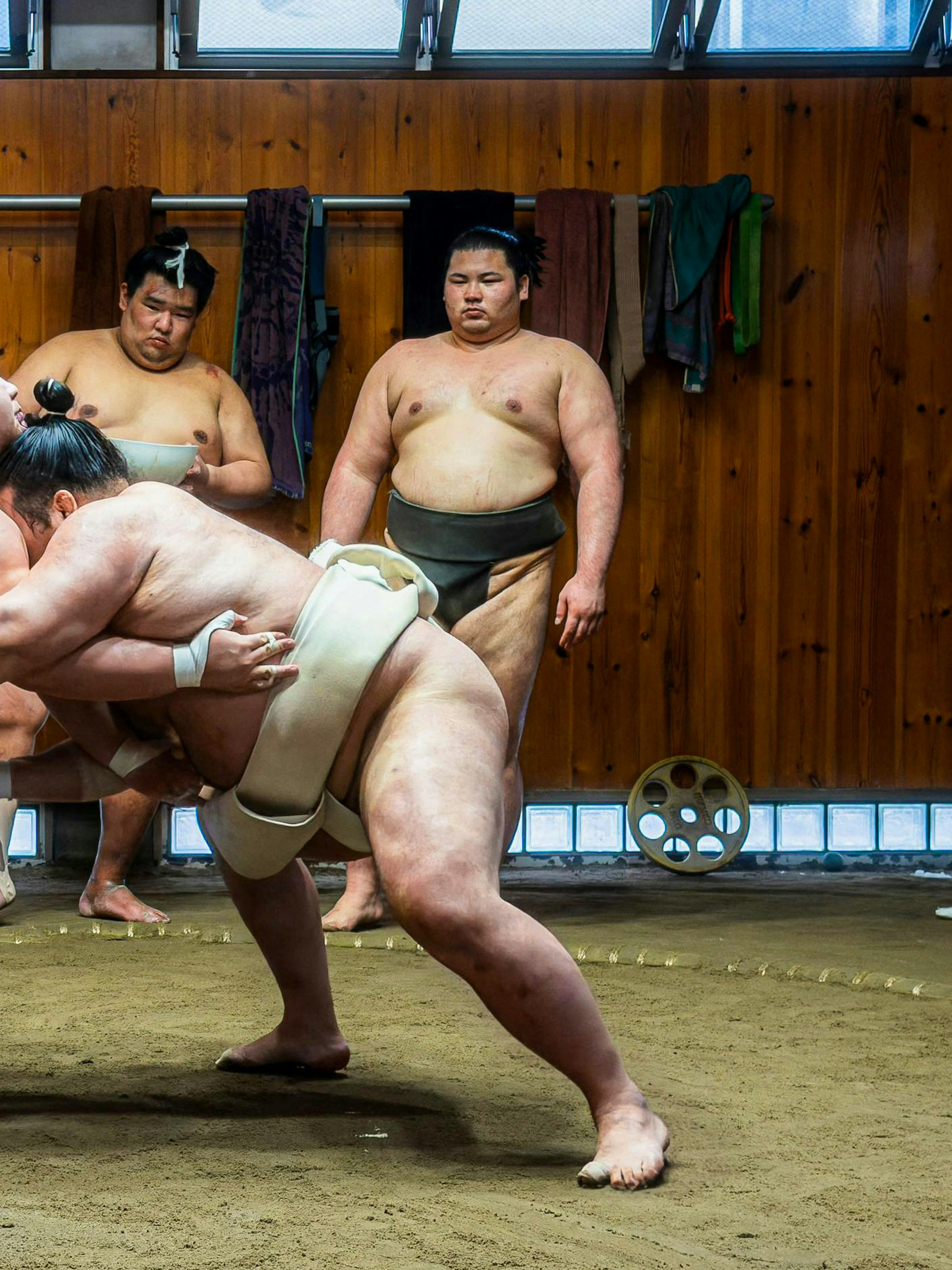 Sumo wrestlers practicing in a traditional dojo during a morning session in Asakusa.