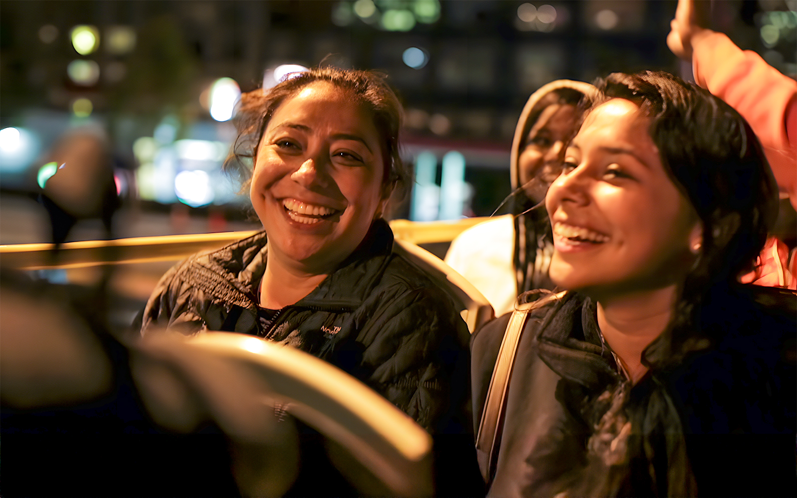 Women enjoying a Christmas light night bus tour in San Francisco.