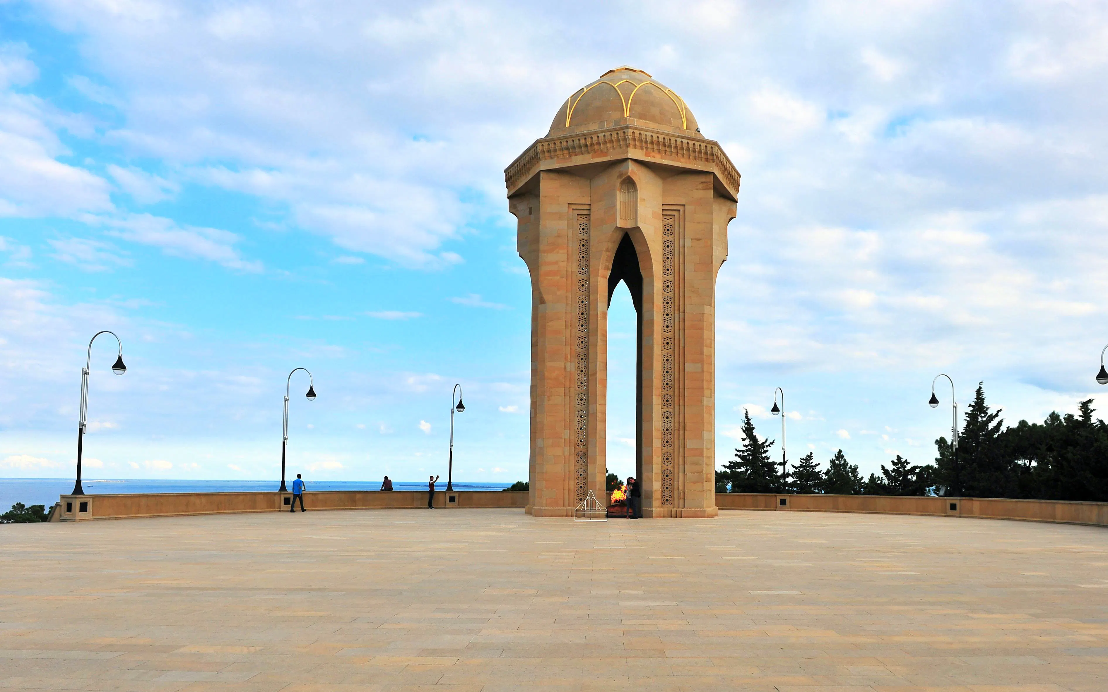 Eternal Flame memorial at Martyrs' Lane, Baku with surrounding plaza and sky.