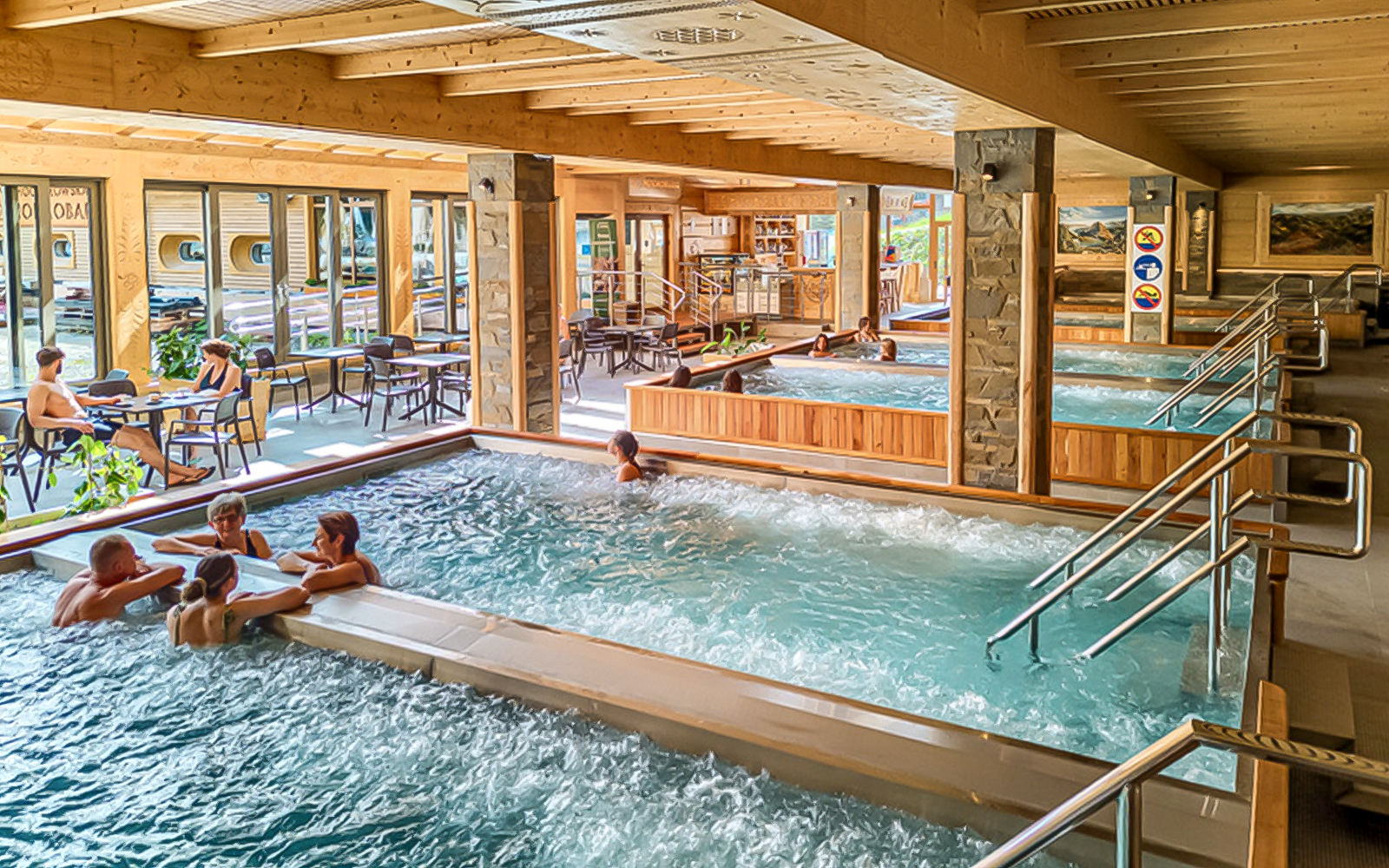 Indoor pools at Chocholow Thermal Baths with people relaxing and socializing.