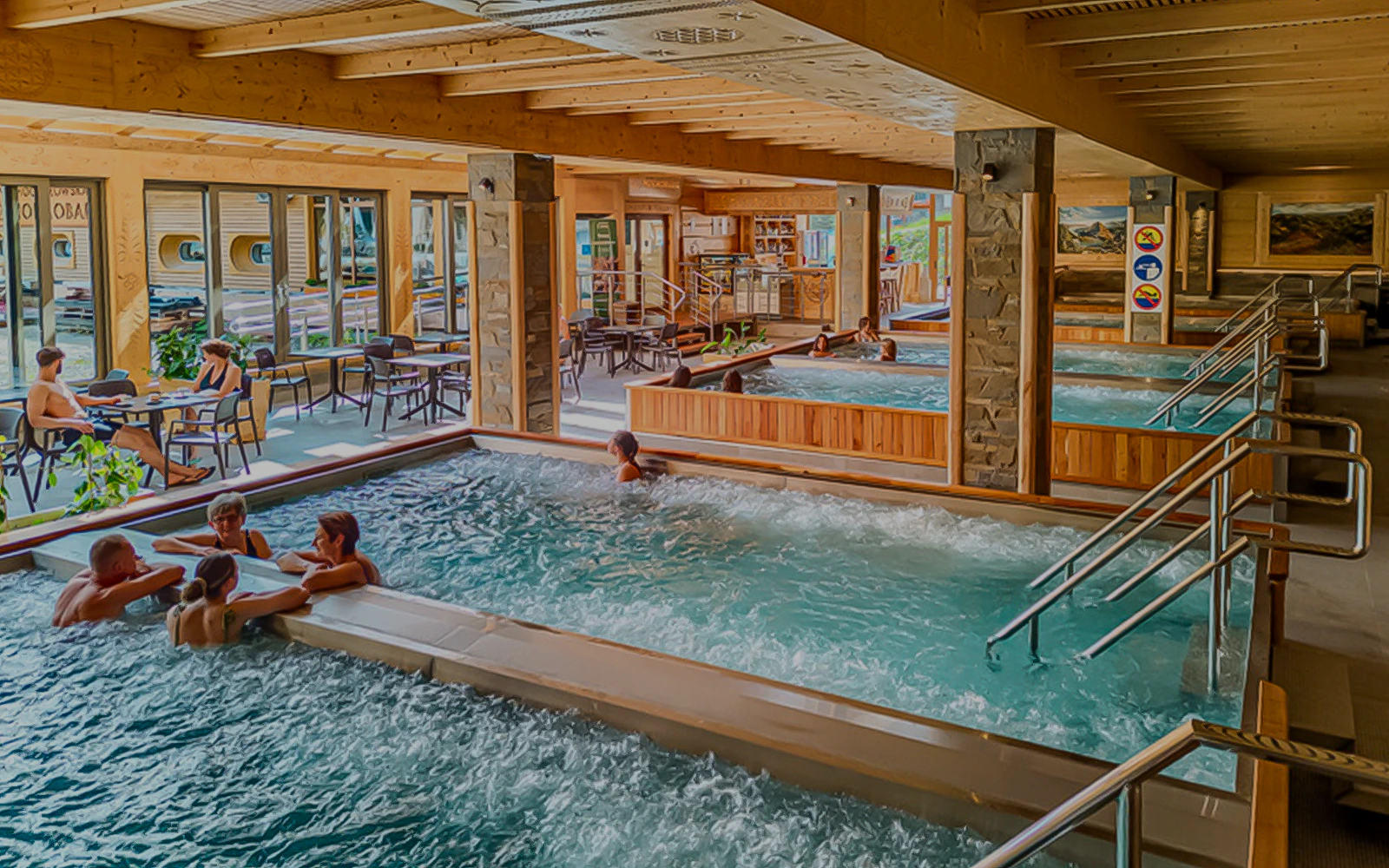 Indoor pools at Chocholow Thermal Baths with people relaxing and socializing.