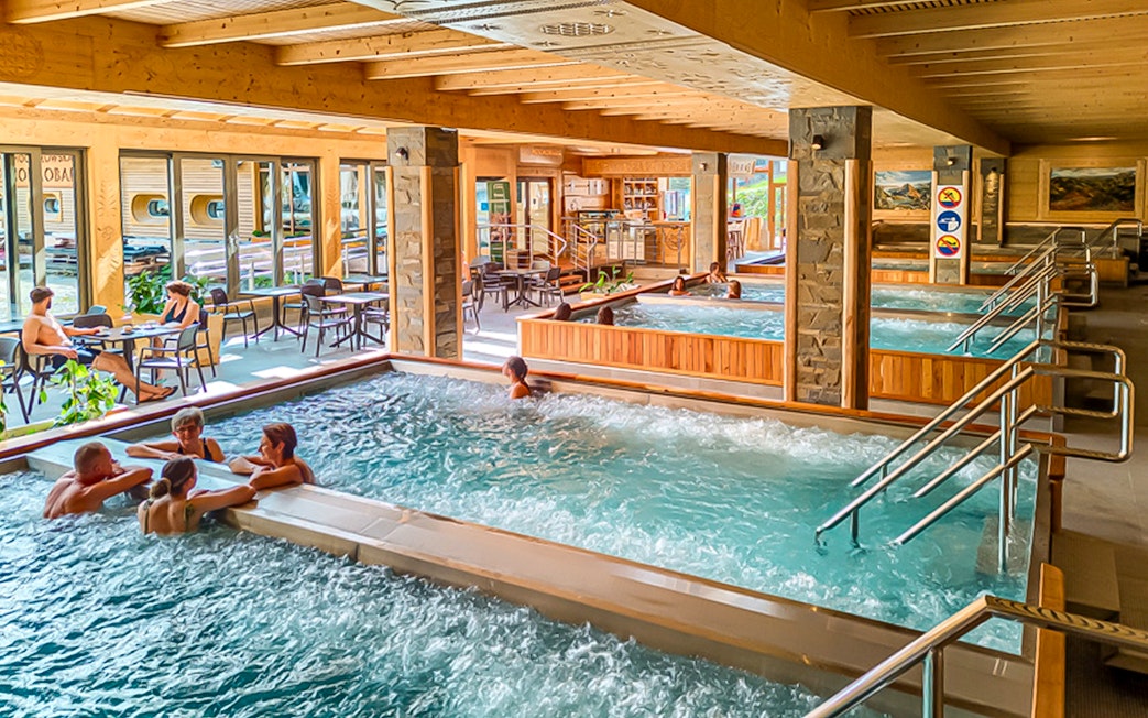 Indoor pools at Chocholow Thermal Baths with people relaxing and socializing.