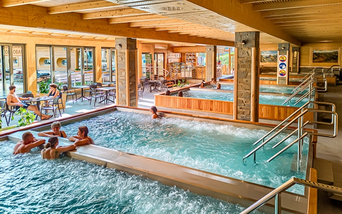 Indoor pools at Chocholow Thermal Baths with people relaxing and socializing.
