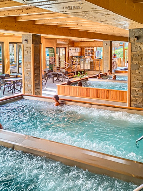 Indoor pools at Chocholow Thermal Baths with people relaxing and socializing.