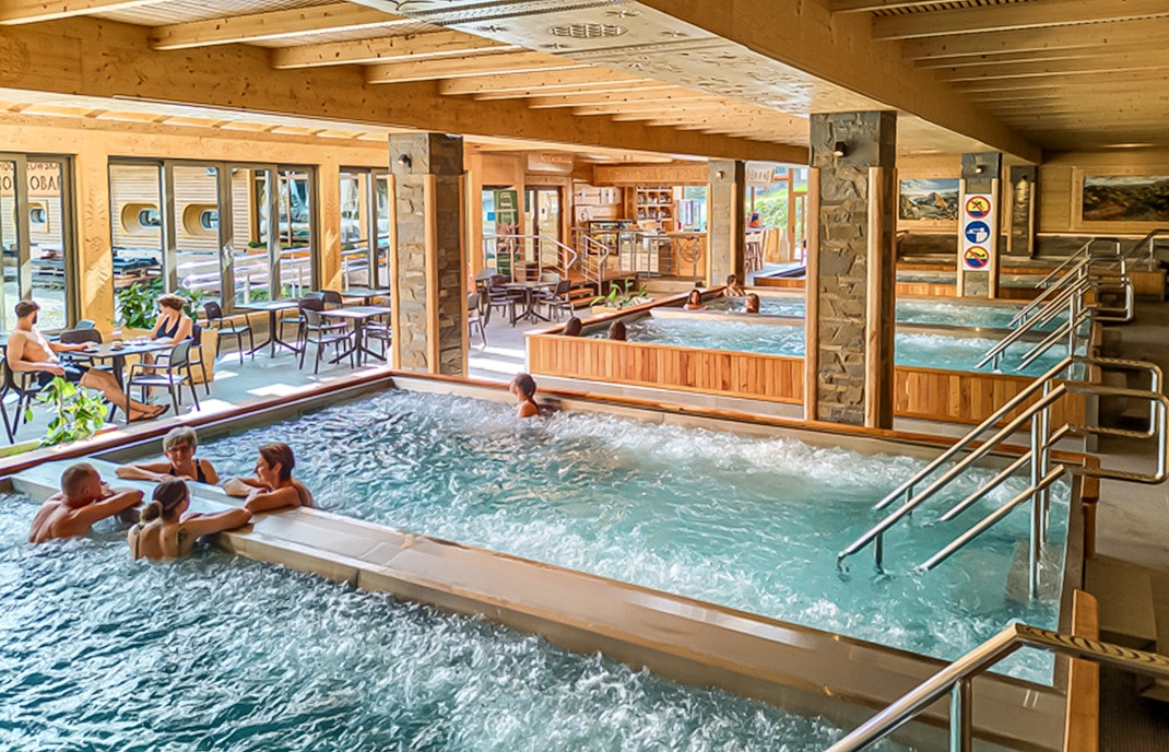 Indoor pools at Chocholow Thermal Baths with people relaxing and socializing.