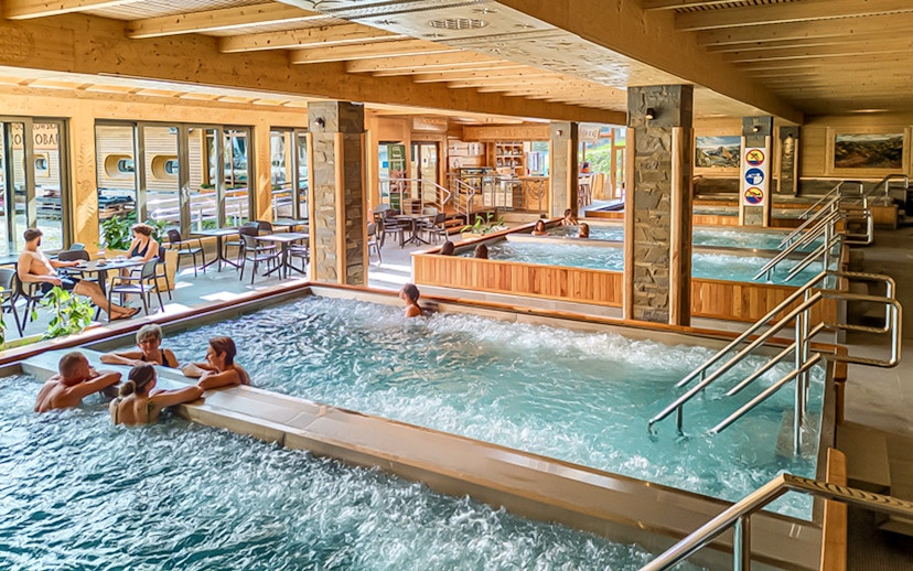 Indoor pools at Chocholow Thermal Baths with people relaxing and socializing.