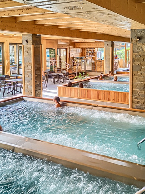 Indoor pools at Chocholow Thermal Baths with people relaxing and socializing.