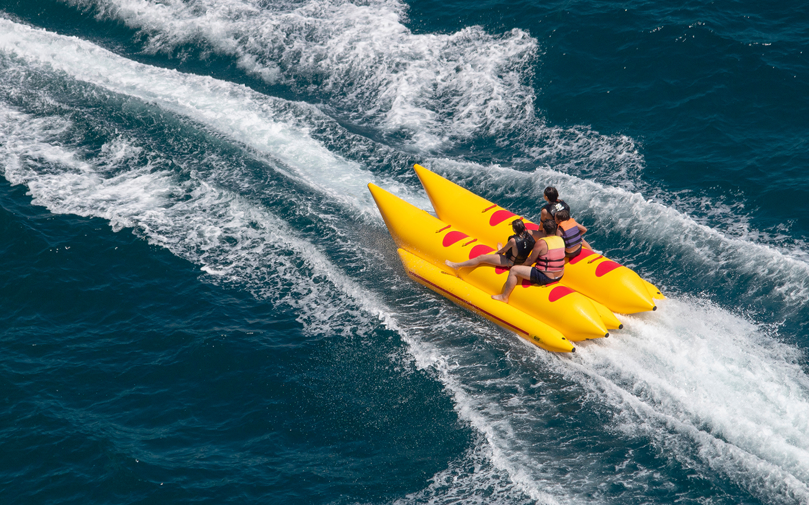 People enjoying a banana boat ride on clear blue waters near Pattaya.