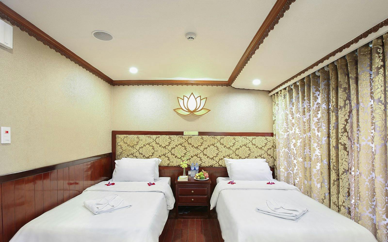 Twin cabin interior on Halong Bay 3-star cruise with decorative lotus wall art.