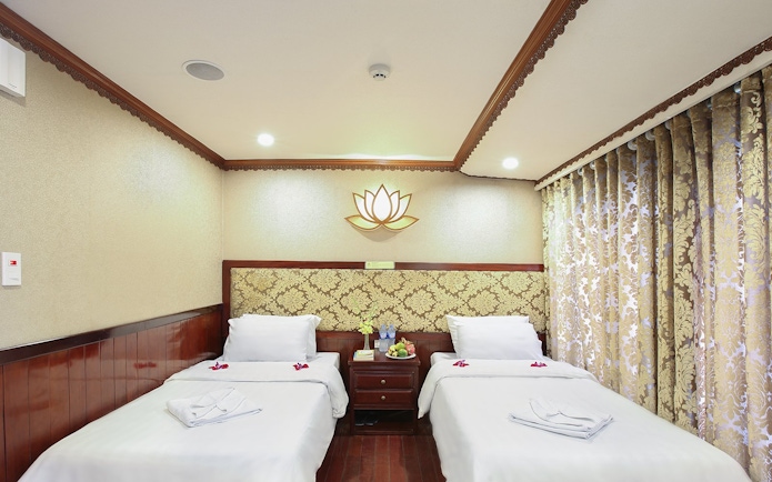 Twin cabin interior on Halong Bay 3-star cruise with decorative lotus wall art.
